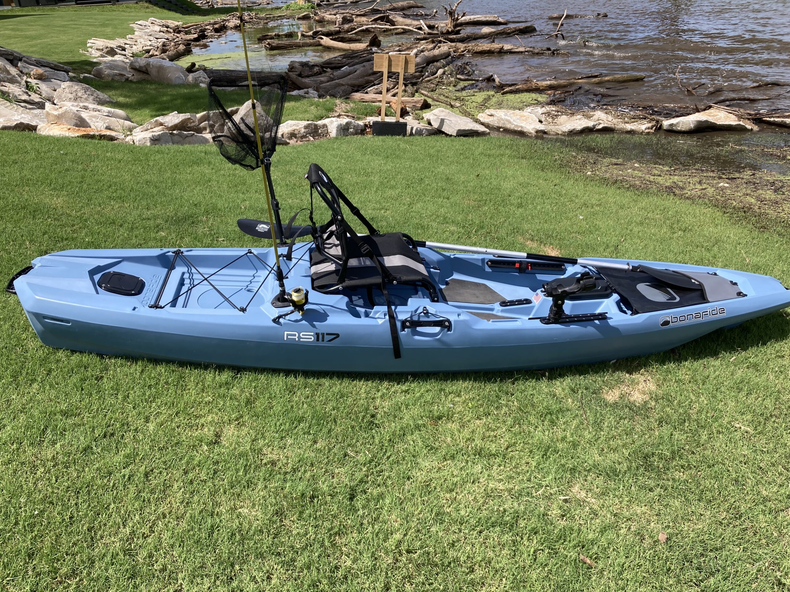 Bonafide RS117 fishing kayak set up with rod, net, and gear ready to launch